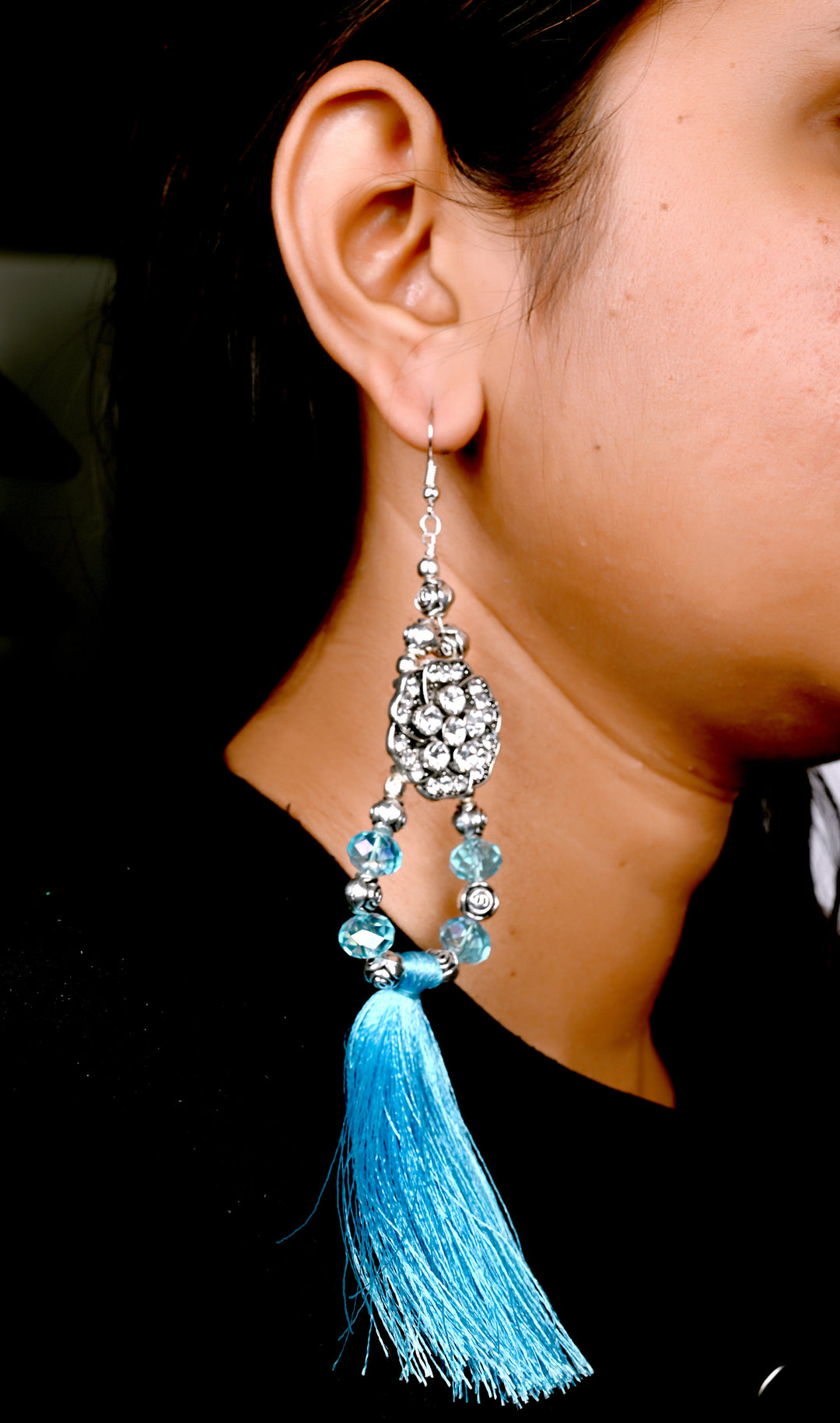 Long Earring Made Of Flower Shaped Metal Beads Having Beads On It, Multi Faceted Glass Beads Strung In Hoop And Styled With Turquoise Colored Tassel
