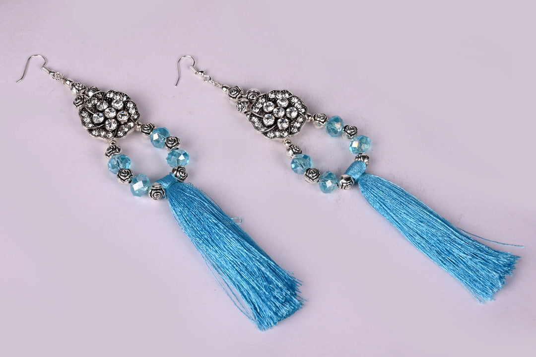 Long Earring Made Of Flower Shaped Metal Beads Having Beads On It, Multi Faceted Glass Beads Strung In Hoop And Styled With Turquoise Colored Tassel