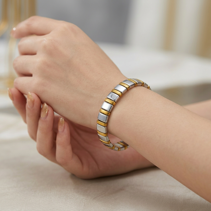 Delemon featuring a uniform two-tone stretch bracelet alternating polished silver-grey hematite blocks with slim gold metallic spacer beads