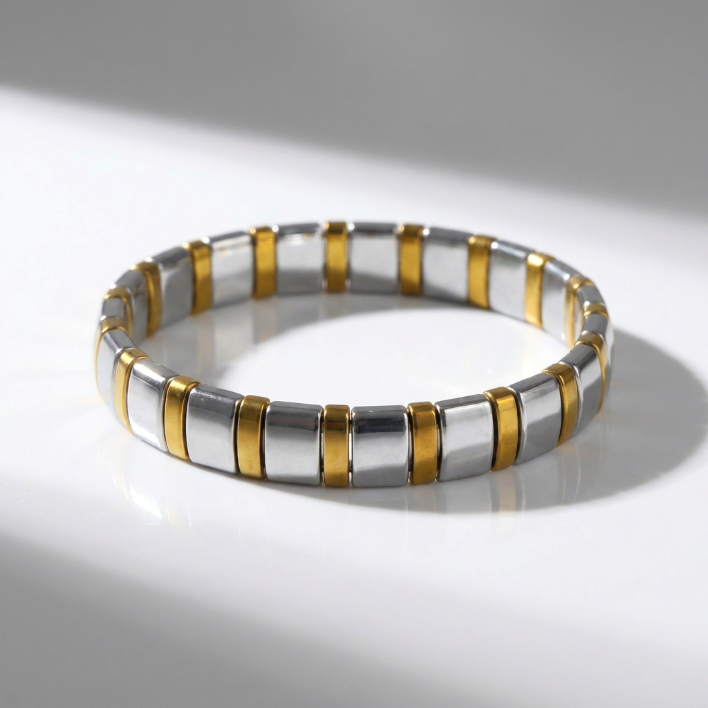Delemon featuring a uniform two-tone stretch bracelet alternating polished silver-grey hematite blocks with slim gold metallic spacer beads