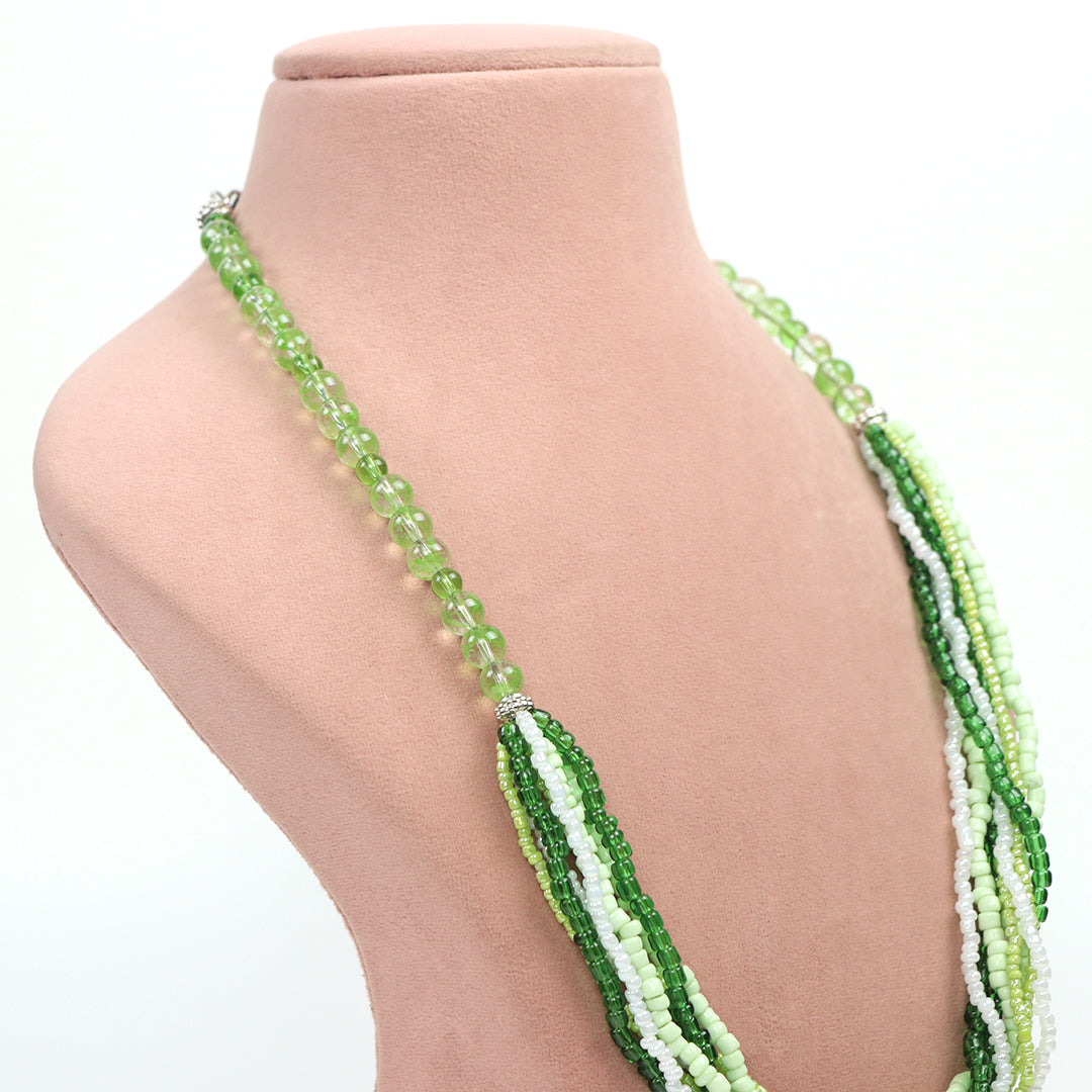 Side profile view of Delemon high-quality multi-strand necklace, showing the transition from shades of green and white seed beads into a single strand of translucent light green round beads.