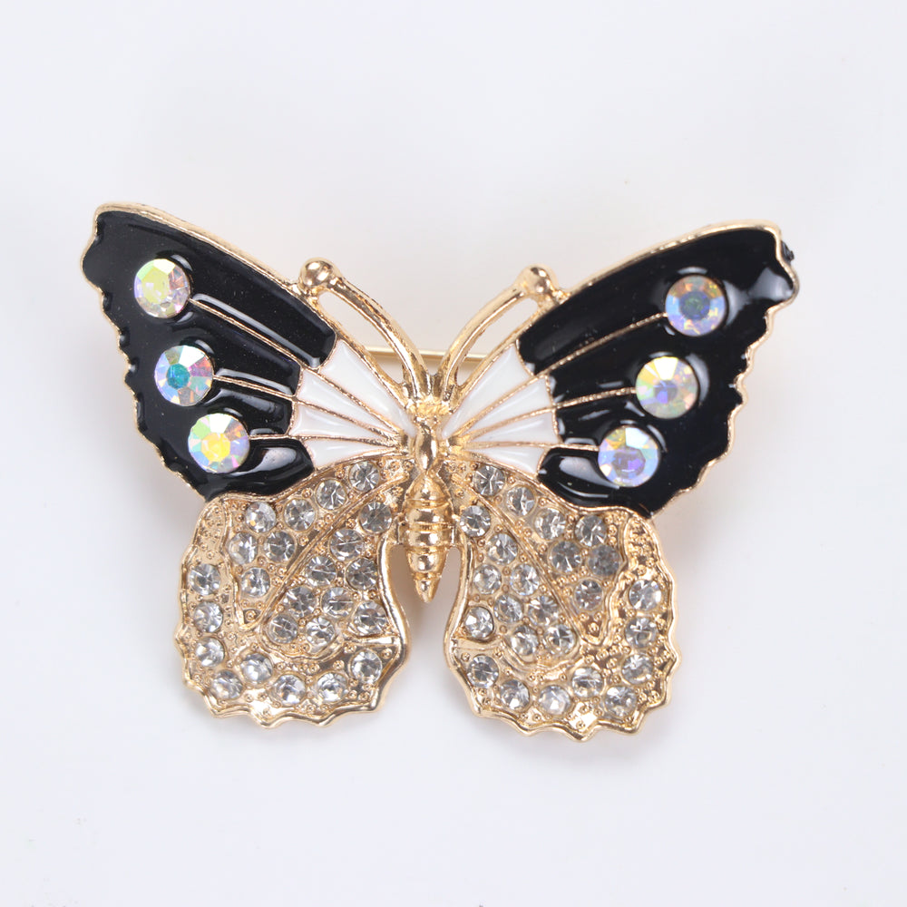 Black and white enamel butterfly brooch pin with iridescent AB crystals and clear pavé lower wings on a white background by Delemon