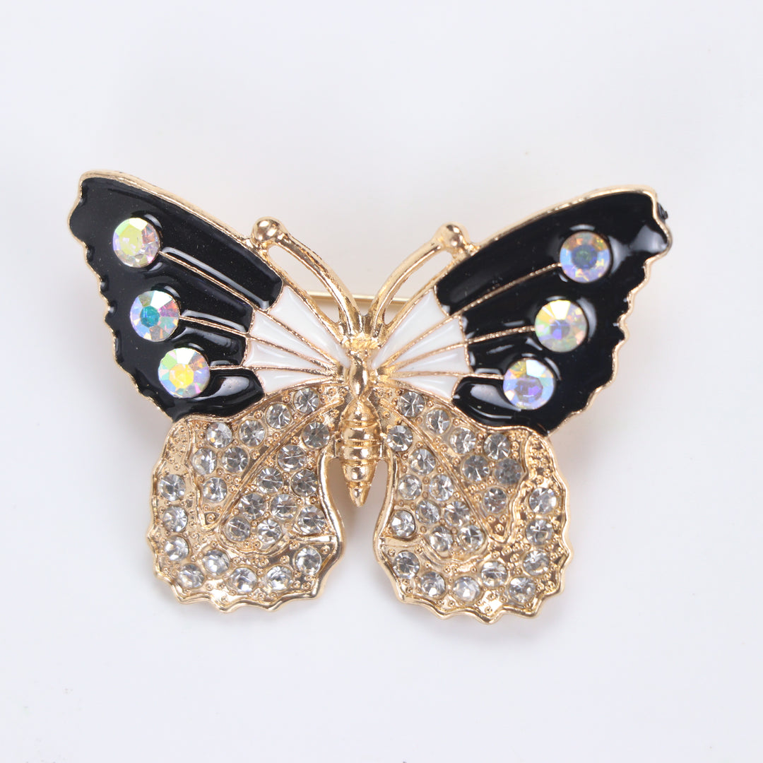 Black and white enamel butterfly brooch pin with iridescent AB crystals and clear pavé lower wings on a white background by Delemon