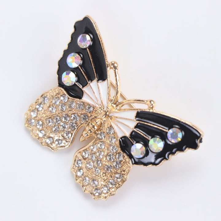 Black and white enamel butterfly brooch pin with iridescent AB crystals and clear pavé lower wings on a white background by Delemon