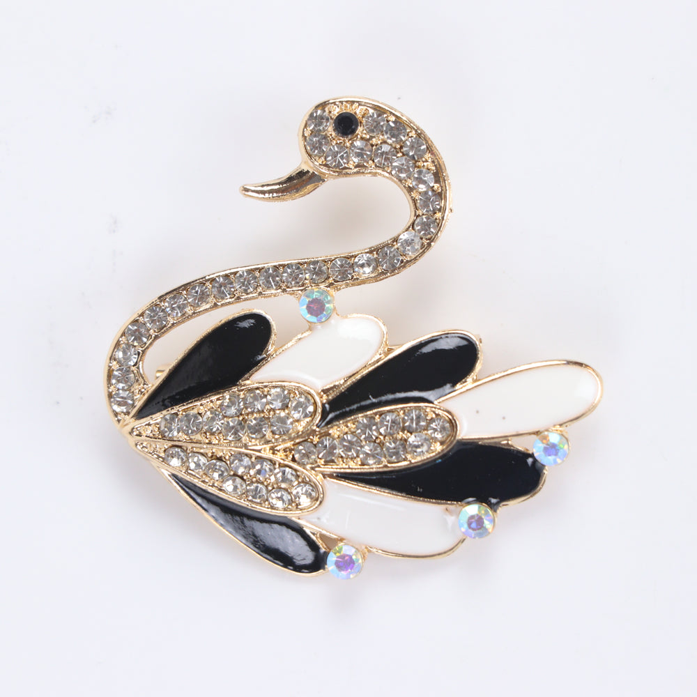 Gold-tone swan brooch pin with black and white enamel feathers, clear crystals, and iridescent rhinestone accents on a white background by Delemon