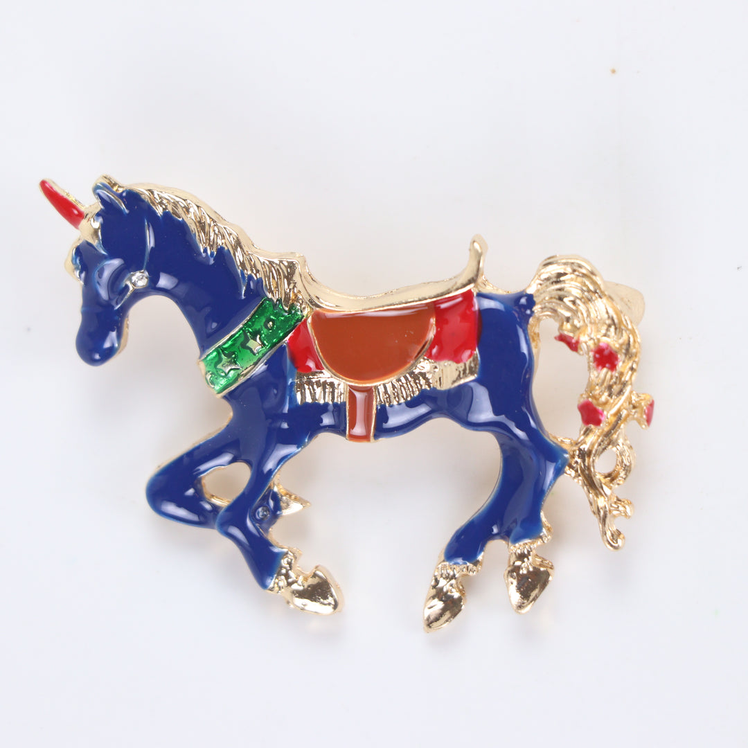 Royal blue enamel carousel horse unicorn brooch pin with colorful saddle accents on a white background by Delemon