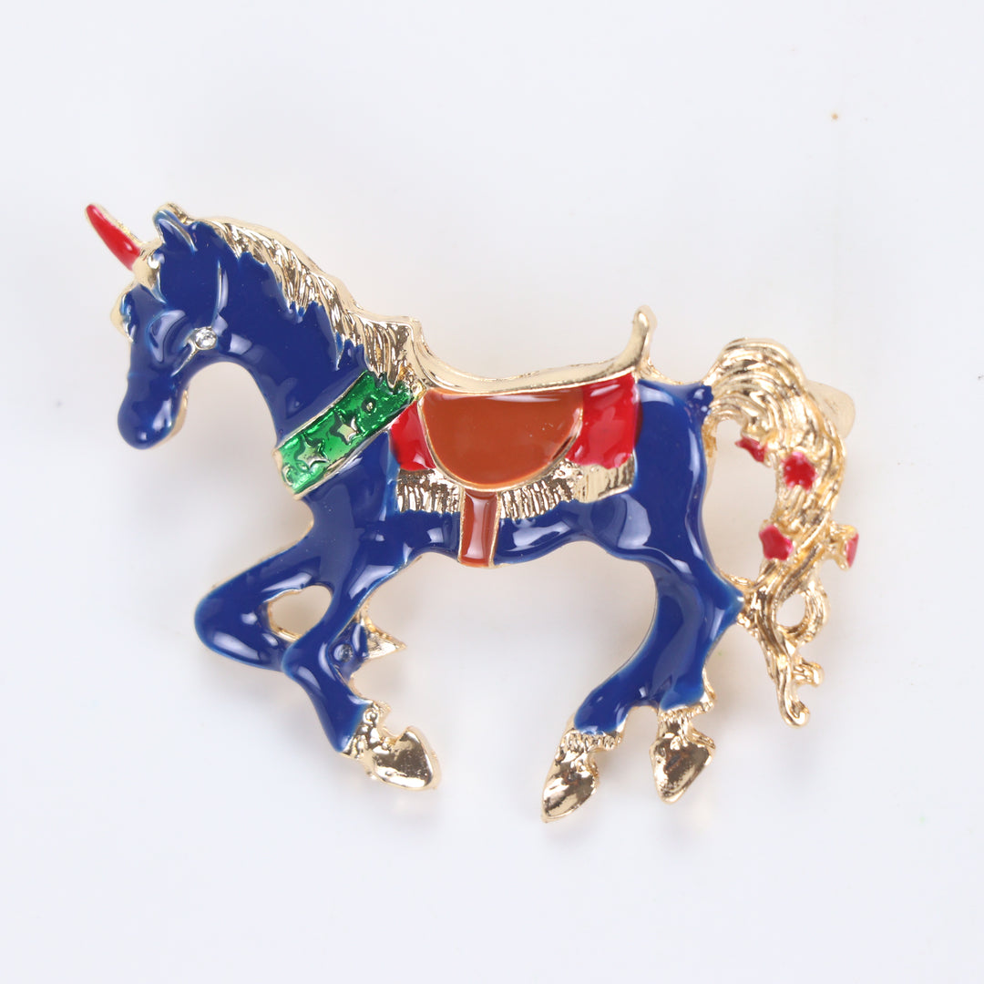 Royal blue enamel carousel horse unicorn brooch pin with colorful saddle accents on a white background by Delemon