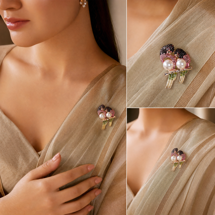 Gold-tone perched lovebirds brooch pin with pink and dark red crystals, olive green tail feathers, and pearl bodies 