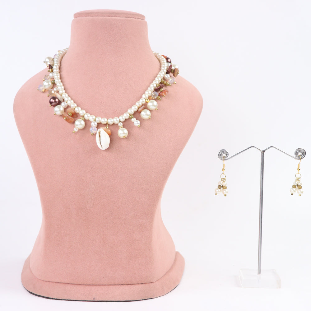 De-lemon cowrie shell center charm pearl necklace with dangling beads and matching cluster earrings on display mannequin.