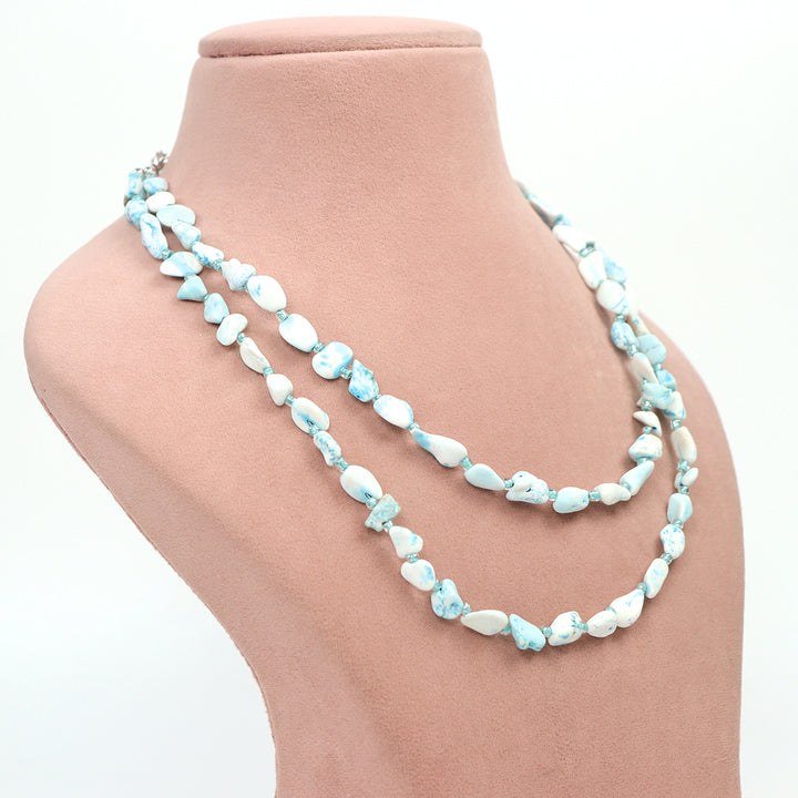 Side view of a Delemon high-quality double-layer necklace crafted with irregular light blue and white marble-textured pebble beads on a pink display bust.