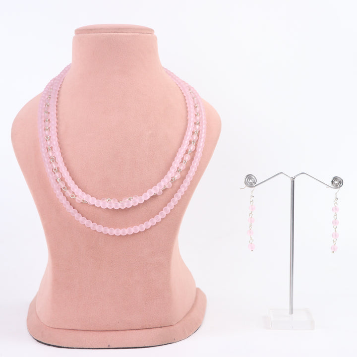 Frosted matte pink multi-strand glass bead necklace and matching drop earrings on a display mannequin - Delemon Collection.