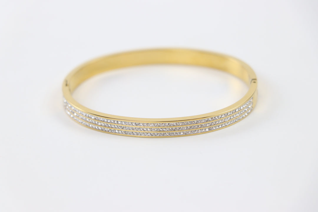 Delemon gold rigid bangle bracelet featuring three rows of clear pavé crystals in waterproof 18k gold plated stainless steel