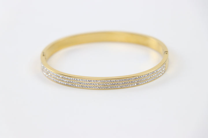 Delemon gold rigid bangle bracelet featuring three rows of clear pavé crystals in waterproof 18k gold plated stainless steel