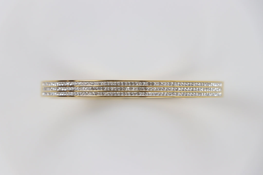Delemon gold rigid bangle bracelet featuring three rows of clear pavé crystals in waterproof 18k gold plated stainless steel