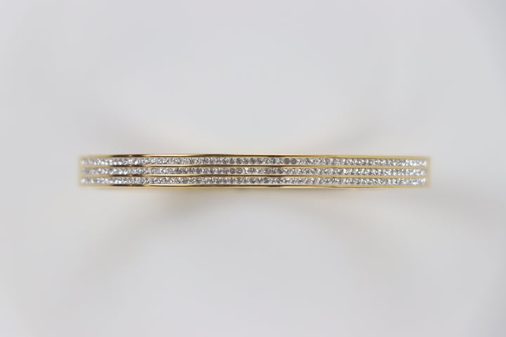 Delemon gold rigid bangle bracelet featuring three rows of clear pavé crystals in waterproof 18k gold plated stainless steel