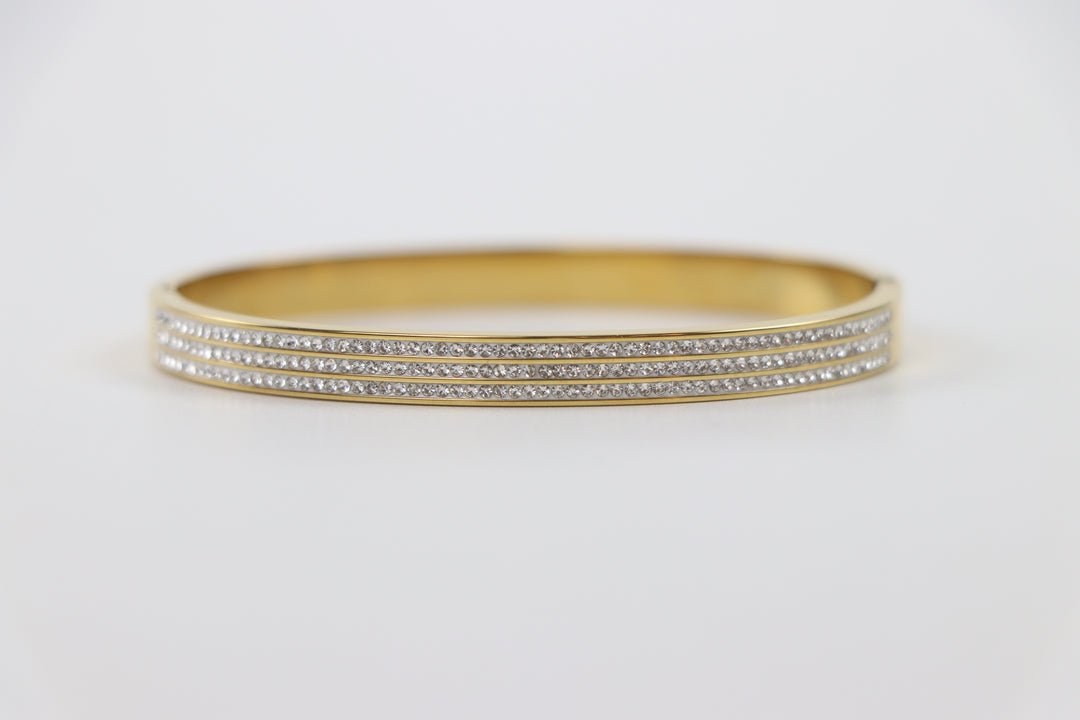 Delemon gold rigid bangle bracelet featuring three rows of clear pavé crystals in waterproof 18k gold plated stainless steel