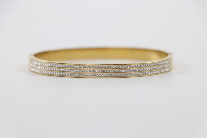 Delemon gold rigid bangle bracelet featuring three rows of clear pavé crystals in waterproof 18k gold plated stainless steel
