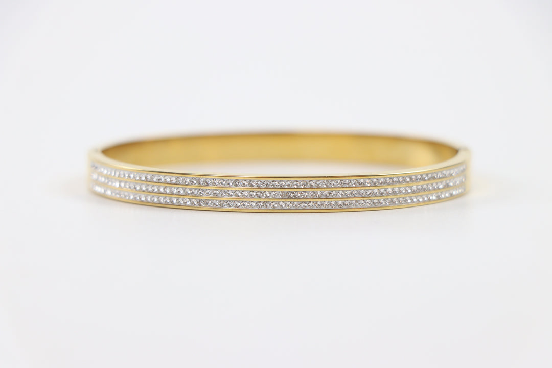 Delemon gold rigid bangle bracelet featuring three rows of clear pavé crystals in waterproof 18k gold plated stainless steel