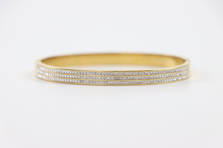 Delemon gold rigid bangle bracelet featuring three rows of clear pavé crystals in waterproof 18k gold plated stainless steel