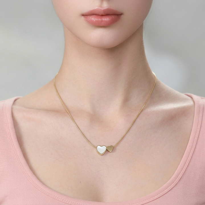 Delemon high-quality gold plated thin snake chain necklace featuring a central double heart pendant with one white mother-of-pearl heart and one smaller solid gold heart