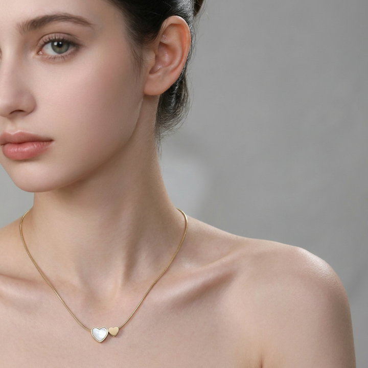 Delemon high-quality gold plated thin snake chain necklace featuring a central double heart pendant with one white mother-of-pearl heart and one smaller solid gold heart