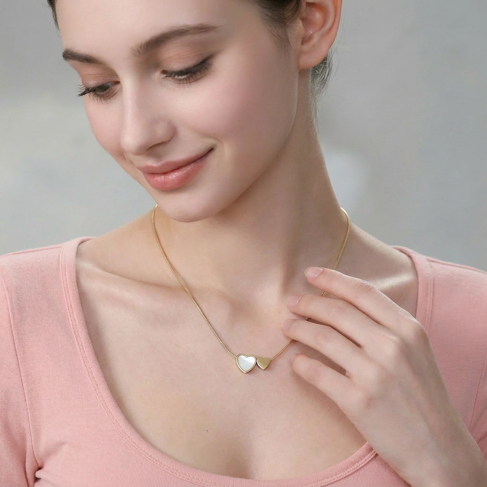 Delemon high-quality gold plated thin snake chain necklace featuring a central double heart pendant with one white mother-of-pearl heart and one smaller solid gold heart