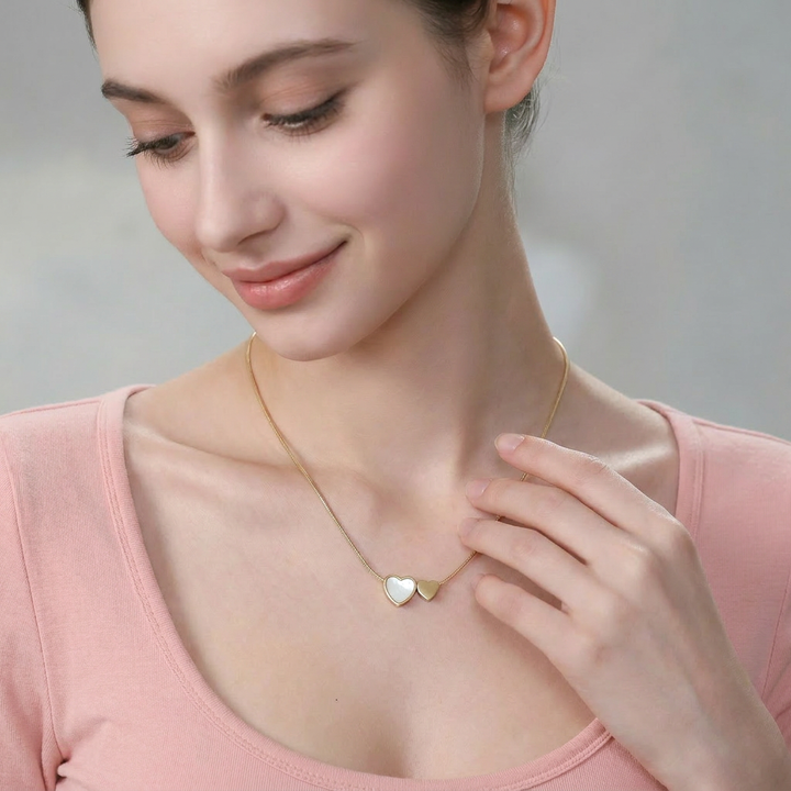Delemon high-quality gold plated thin snake chain necklace featuring a central double heart pendant with one white mother-of-pearl heart and one smaller solid gold heart