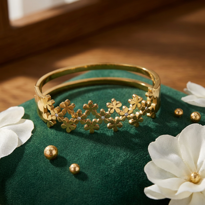 Delemon high-quality gold plated stainless steel bangle bracelet featuring an intricate clustered design of small five-petal flowers accented with delicate crystals