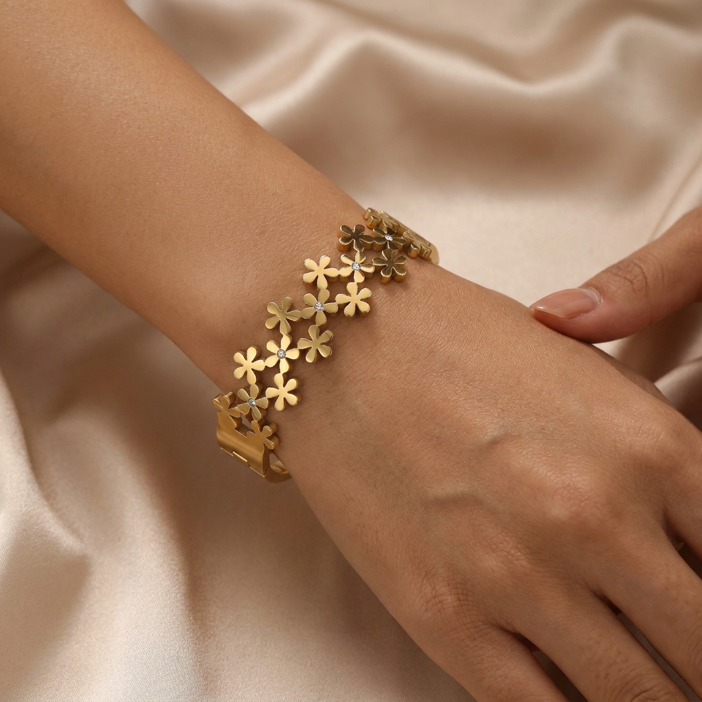 Delemon high-quality gold plated stainless steel bangle bracelet featuring an intricate clustered design of small five-petal flowers accented with delicate crystals