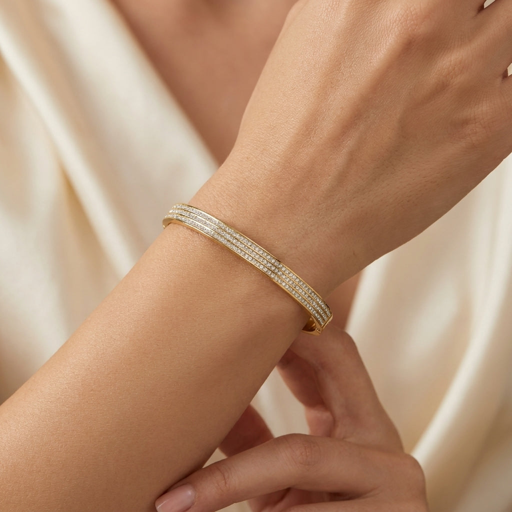 Delemon gold rigid bangle bracelet featuring three rows of clear pavé crystals in waterproof 18k gold plated stainless steel