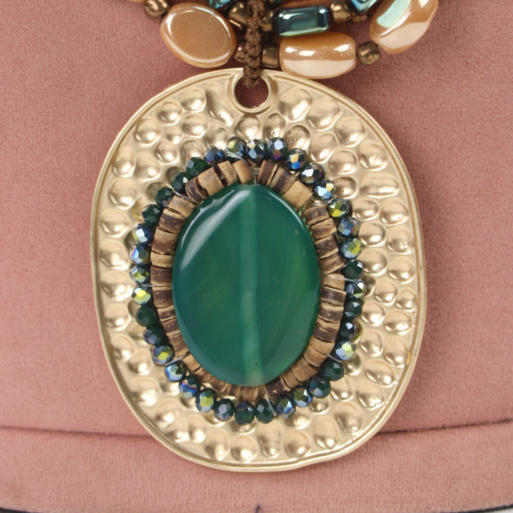Delemon green cabochon stone on hammered gold oval pendant multi-strand wooden bead necklace