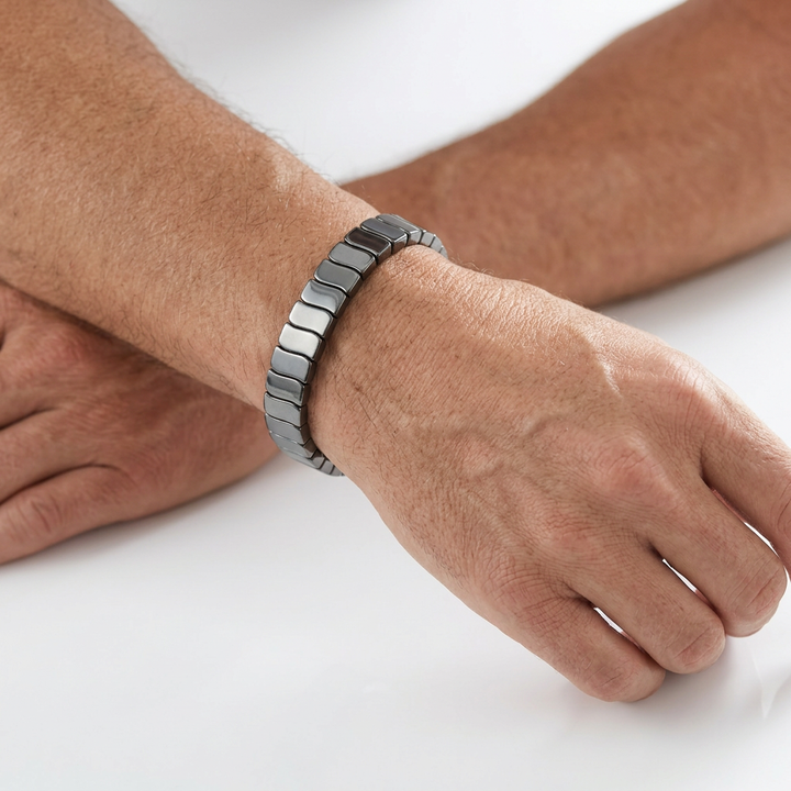 Delemon featuring a uniform stretch bracelet with slim, gently curved polished metallic hematite rectangular drum blocks