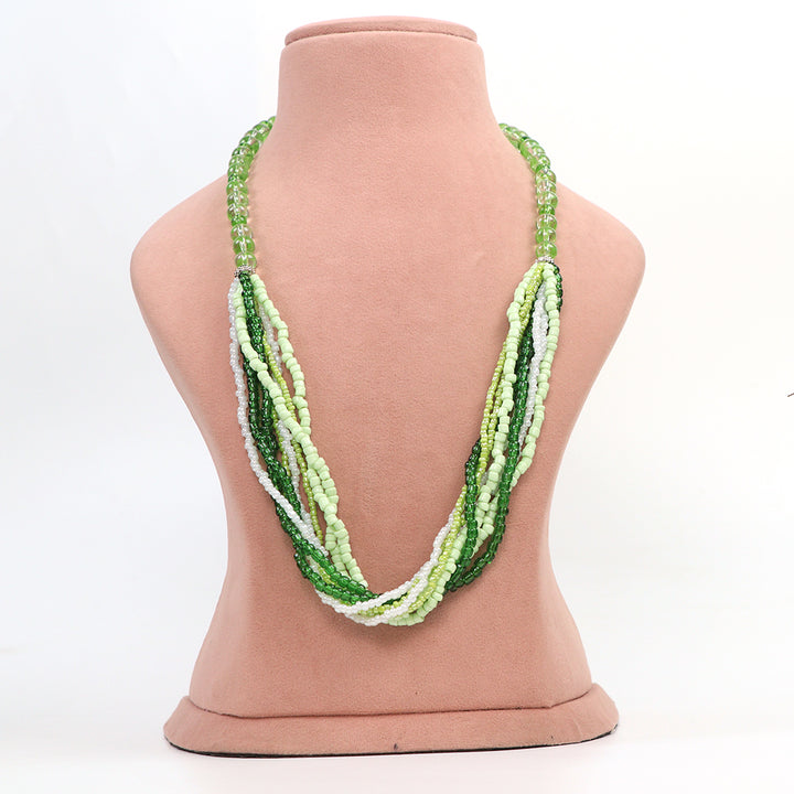 Front view of Delemon high-quality multi-strand necklace made of light green, dark green, and white seed beads on a pink display bust.