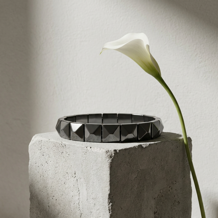 Delemon featuring a uniform geometric stretch bracelet with polished square-based pyramid stud hematite