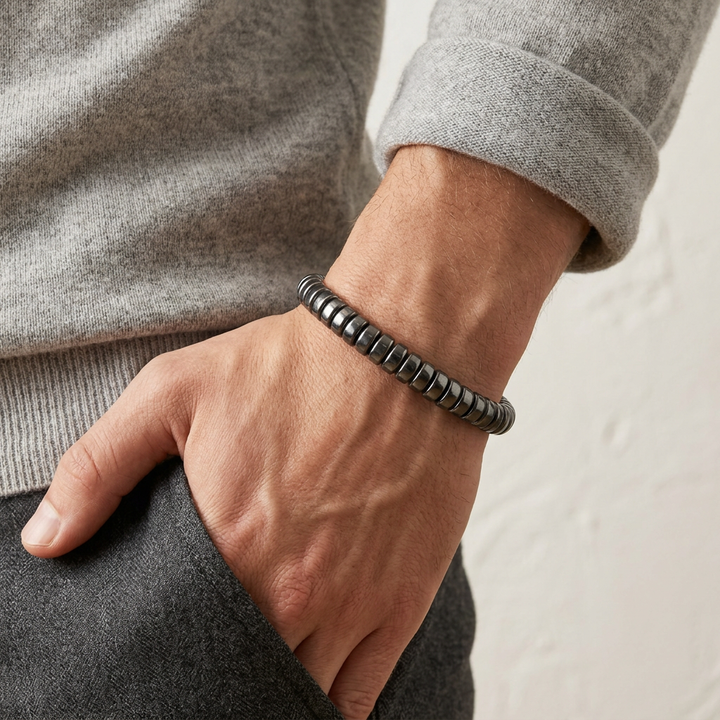Delemon featuring a uniform stretch bracelet with softly rounded polished metallic hematite drum block beads