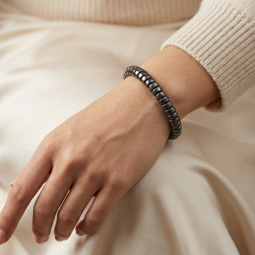 Delemon featuring a uniform stretch bracelet with softly rounded polished metallic hematite drum block beads