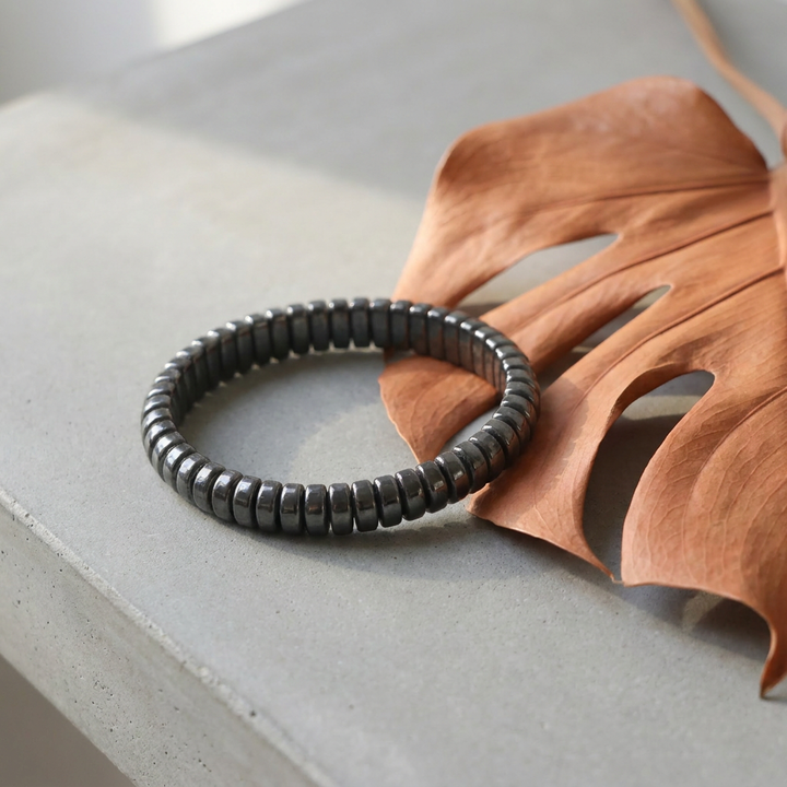 Delemon featuring a uniform stretch bracelet with softly rounded polished metallic hematite drum block beads