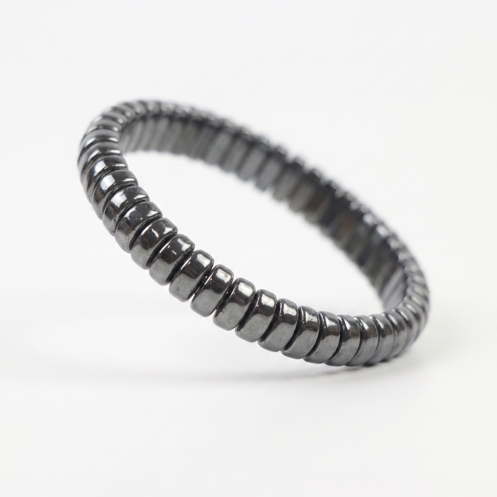 Delemon featuring a uniform stretch bracelet with softly rounded polished metallic hematite drum block beads