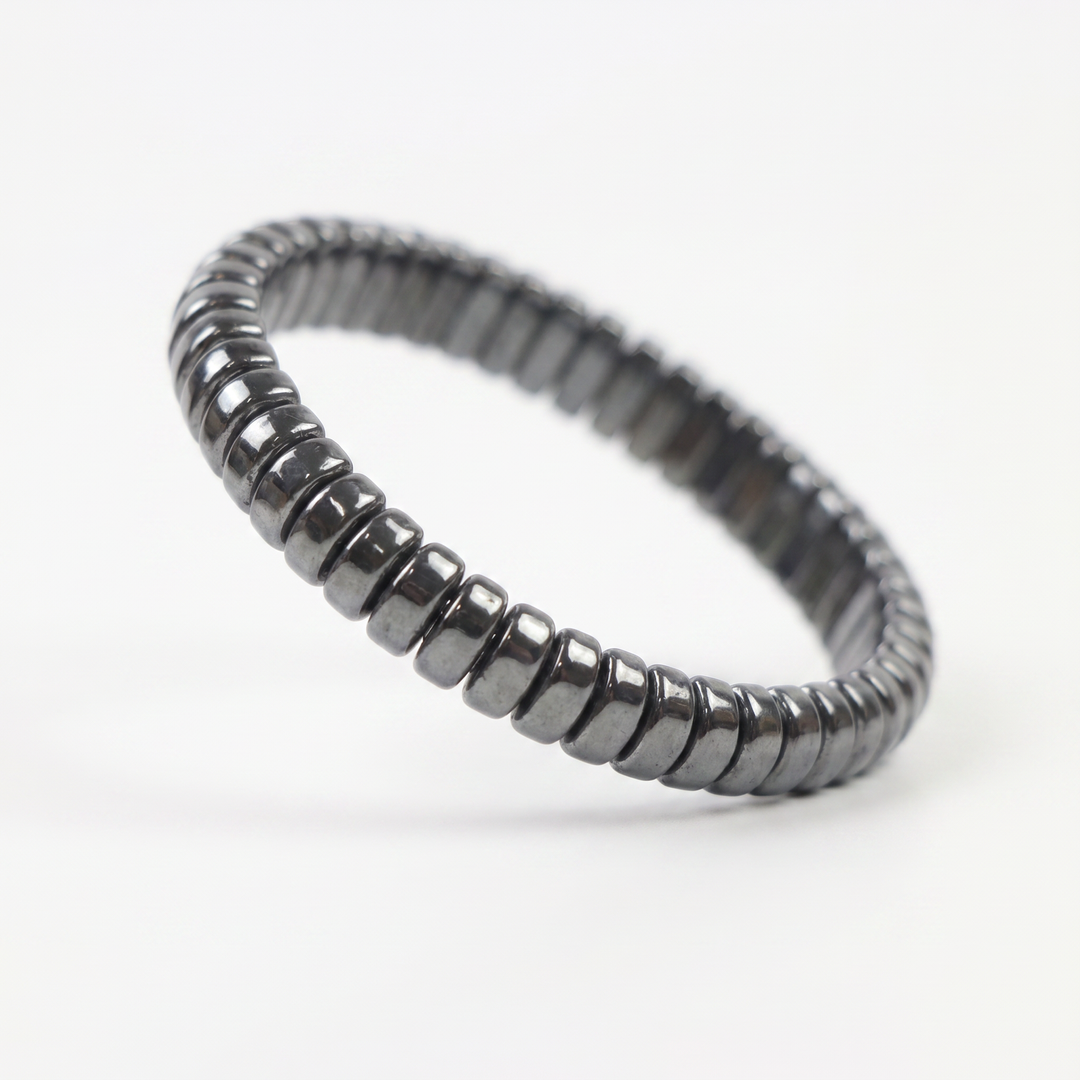 Delemon featuring a uniform stretch bracelet with softly rounded polished metallic hematite drum block beads