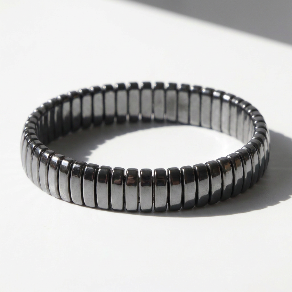 Delemon featuring a uniform full hematite block stretch bracelet with polished rectangular drum bead