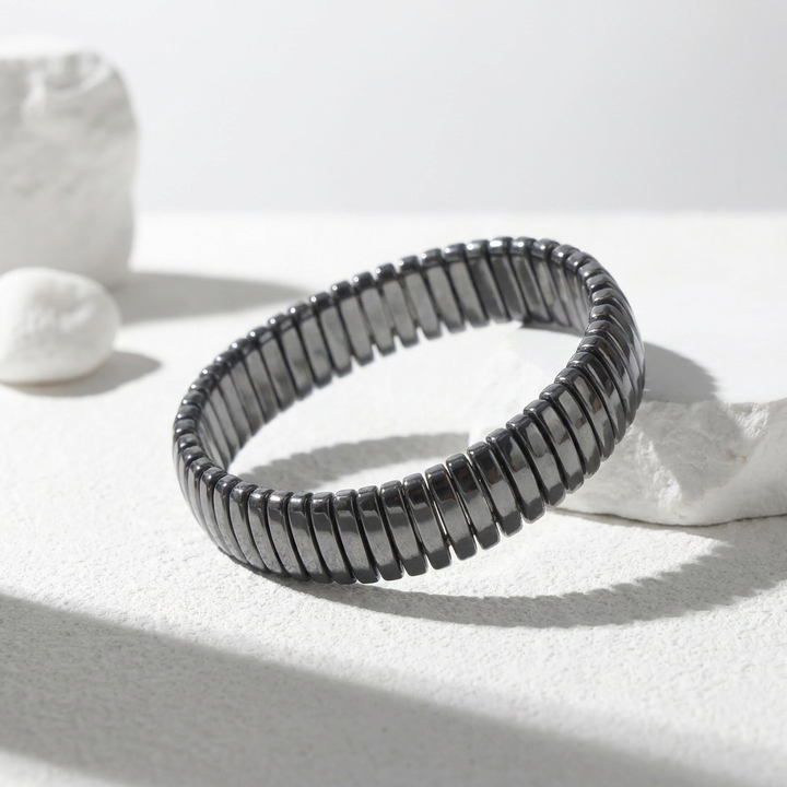 Delemon featuring a uniform full hematite block stretch bracelet with polished rectangular drum bead