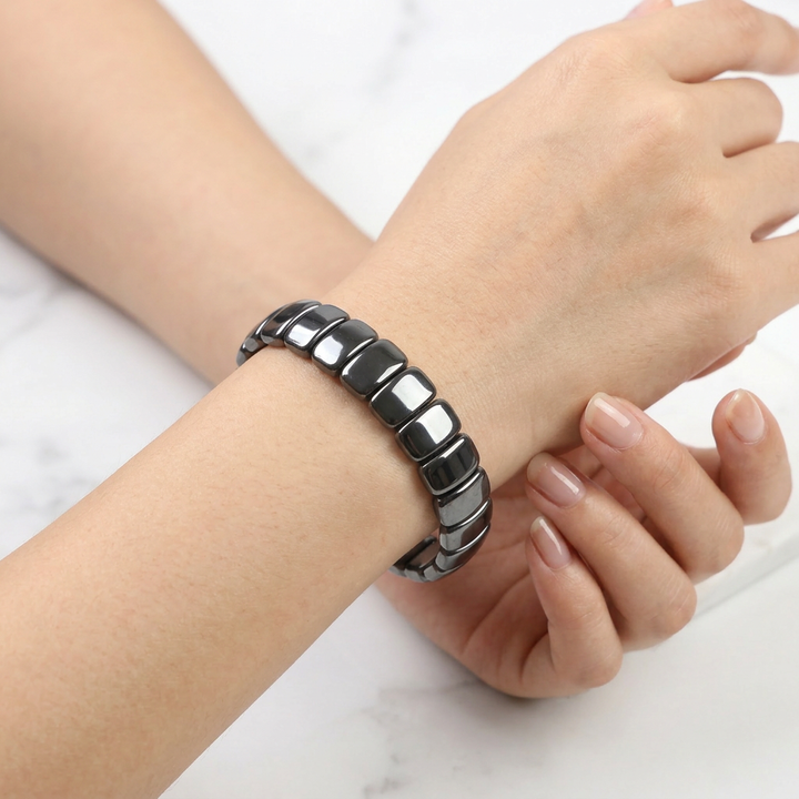 Delemon featuring a uniform stretch bracelet with wide, flat-backed polished metallic hematite