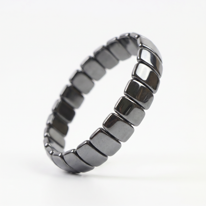 Delemon featuring a uniform stretch bracelet with wide, flat-backed polished metallic hematite