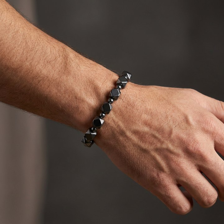 Delemon featuring a uniform geometric stretch bracelet alternating polished multi-faceted hexagonal hematite blocks with tiny round spacer beads