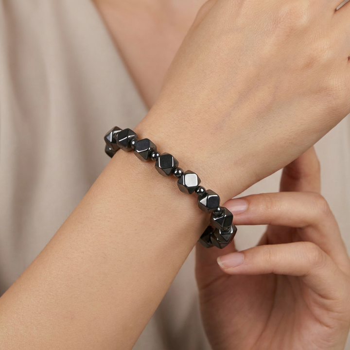 Delemon featuring a uniform geometric stretch bracelet alternating polished multi-faceted hexagonal hematite blocks with tiny round spacer beads