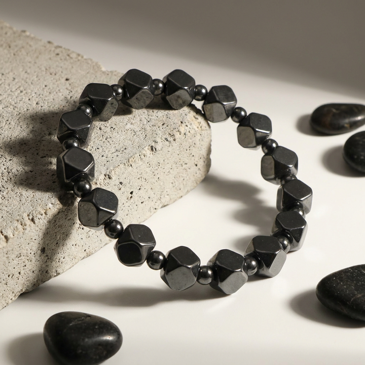 Delemon featuring a uniform geometric stretch bracelet alternating polished multi-faceted hexagonal hematite blocks with tiny round spacer beads