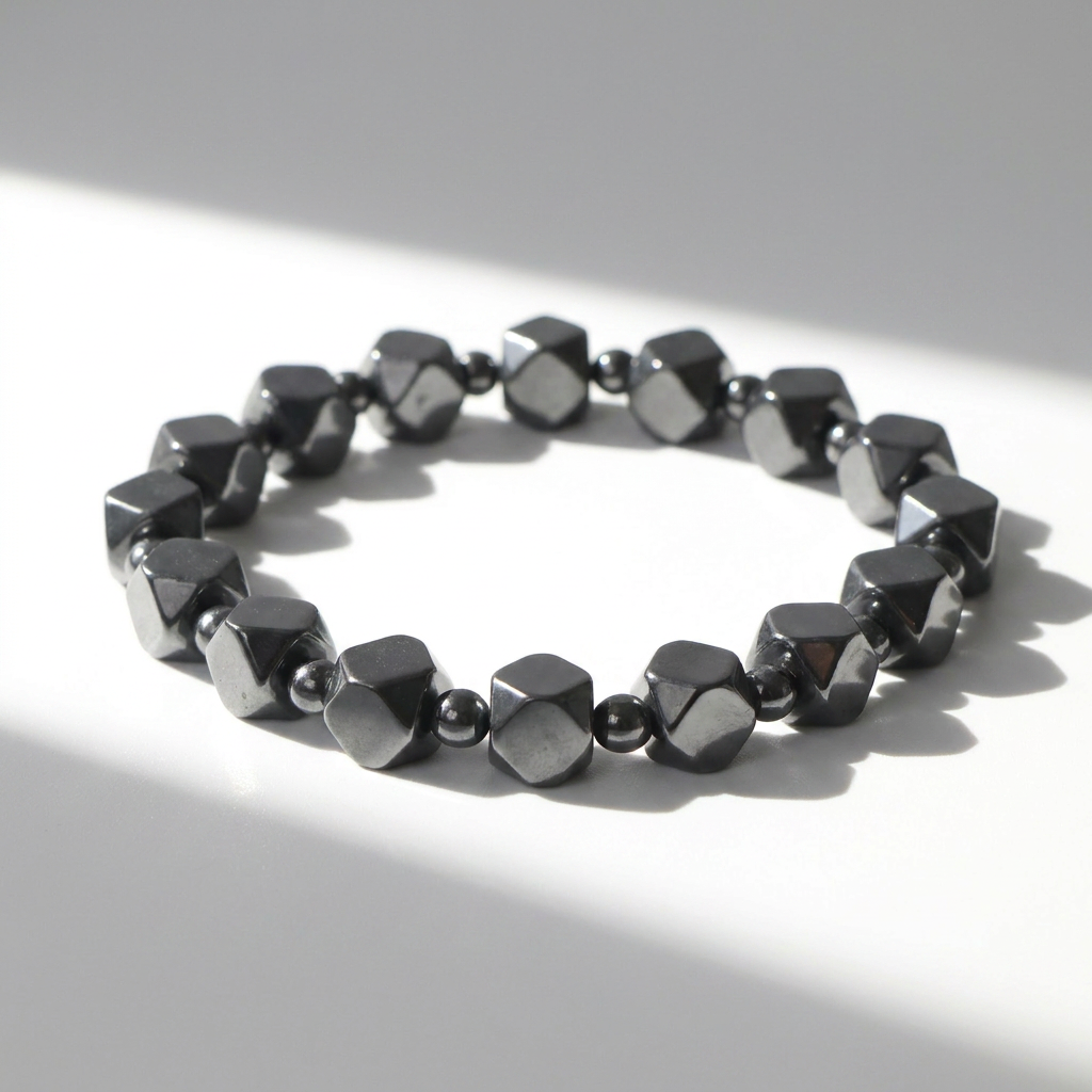 Delemon featuring a uniform geometric stretch bracelet alternating polished multi-faceted hexagonal hematite blocks with tiny round spacer beads