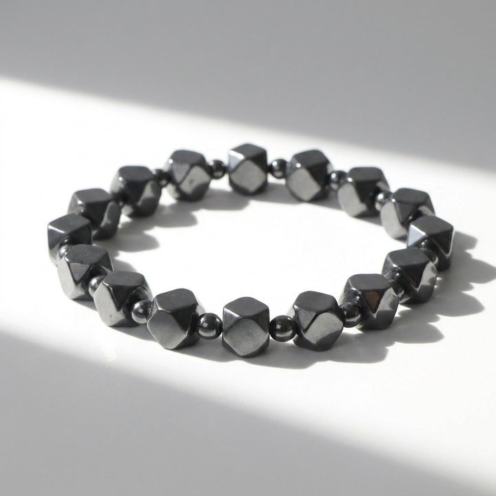 Delemon featuring a uniform geometric stretch bracelet alternating polished multi-faceted hexagonal hematite blocks with tiny round spacer beads