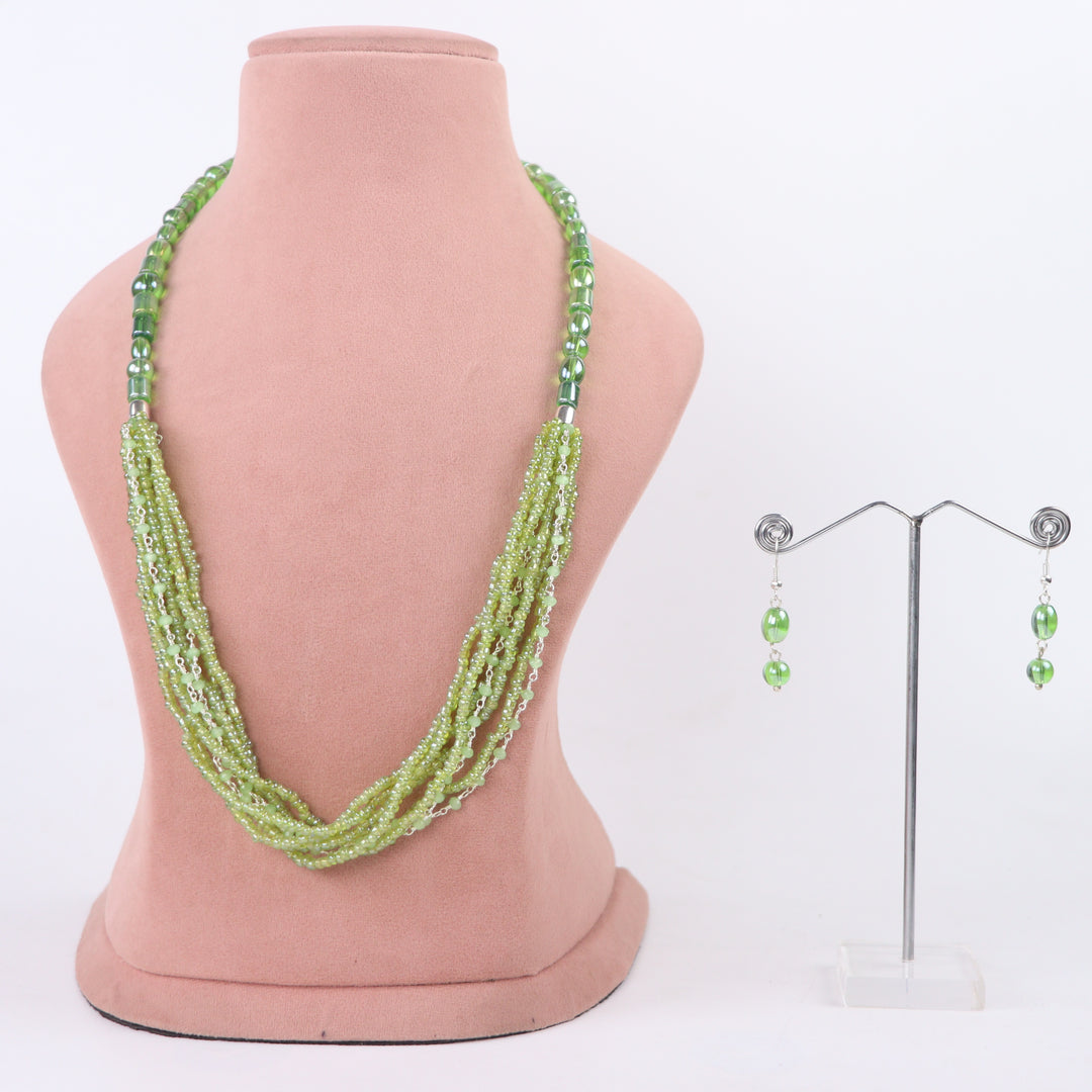 Olive green multi-strand seed bead necklace with chain accents and matching earrings on a pink display - delemon Collection.
