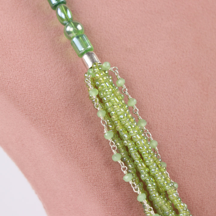 Olive green multi-strand seed bead necklace with chain accents and matching earrings on a pink display - delemon Collection.